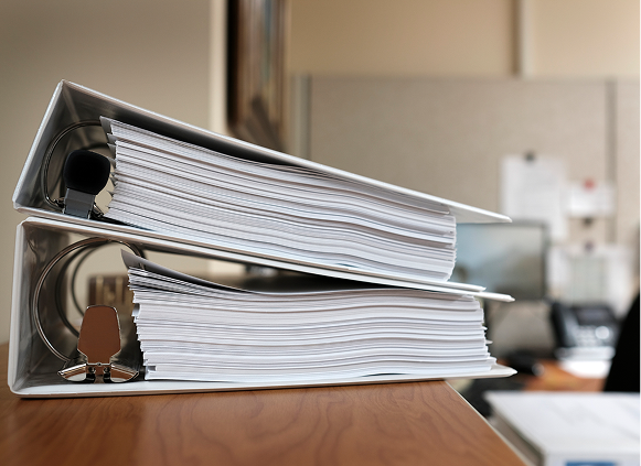 Stacked binders on a desk