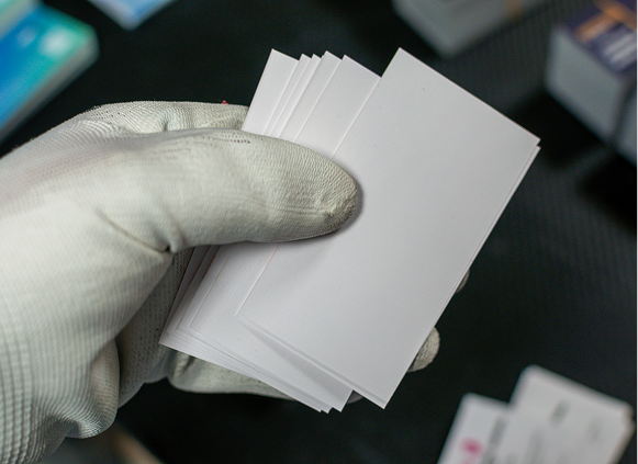 Stack of white cards in gloved hand