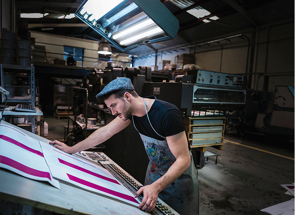 Man inspecting prints in a factory