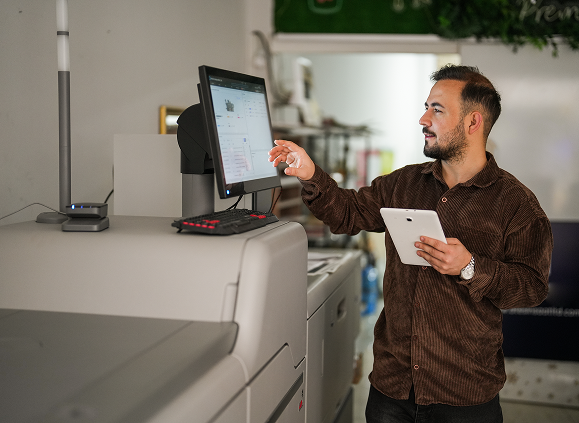Man using touchscreen printer in office